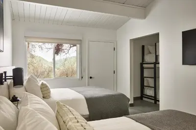a white bedroom with two beds and a window at AutoCamp Sequoia in Three Rivers