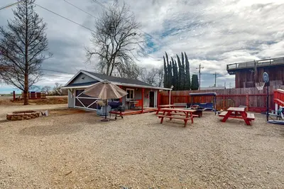 a small house with picnic tables and an umbrella at Riverside Retreat in Bethel Island Fish and Boat! in Bethel Island