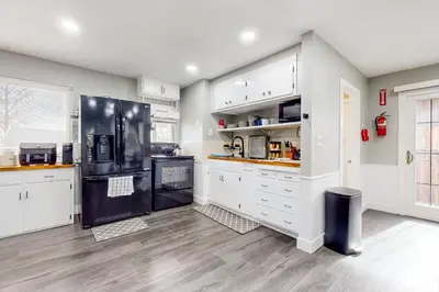 a kitchen with white cabinets and a black refrigerator at Riverside Retreat in Bethel Island Fish and Boat! in Bethel Island