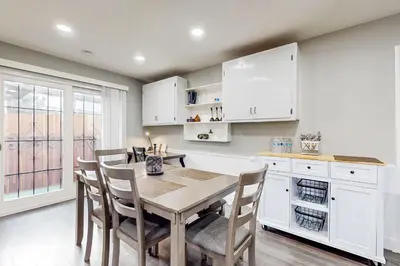 a kitchen with white cabinets and a table and chairs at Riverside Retreat in Bethel Island Fish and Boat! in Bethel Island
