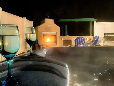 two glasses of wine sitting next to a bath tub at Peacock House Sleeps 12 Hot Tub Game Room in Ahwahnee