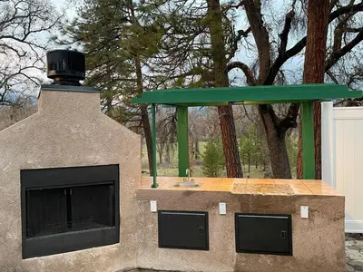 a play house with a fireplace and a green roof at Peacock House Sleeps 12 Hot Tub Game Room in Ahwahnee