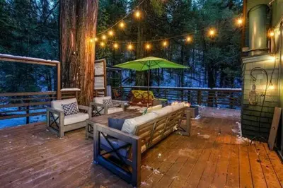 a wooden deck with a bench and an umbrella at Starlight Cabin in Oakhurst