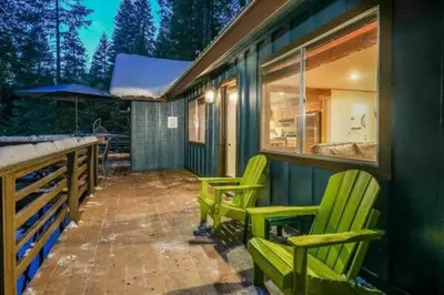 two green chairs sitting on a porch of a house at Starlight Cabin in Oakhurst