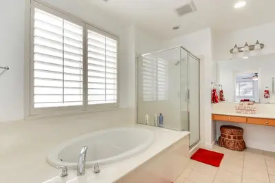 a white bathroom with a tub and a shower at 4 Mi to Dtwn Merced Spacious Home with Yard! in Merced
