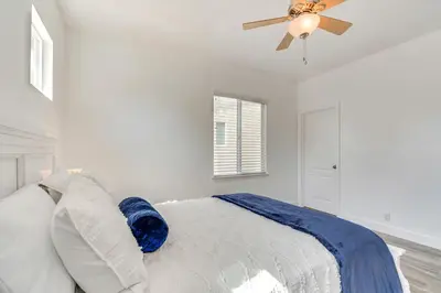 a white bedroom with a bed and a ceiling fan at 4 Mi to Dtwn Merced Spacious Home with Yard! in Merced