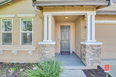 a house with a blue door and columns at 4 Mi to Dtwn Merced Spacious Home with Yard! in Merced