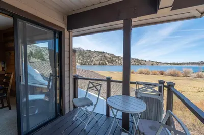a balcony with a table and chairs and a view of a lake at Rr-edgewater10 in June Lake