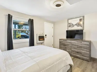 a bedroom with a bed and a flat screen tv at Charming Retro Property 6 in Sparks