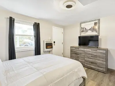 a bedroom with a bed and a flat screen tv at Charming Retro Property 6 in Sparks