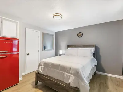a bedroom with a bed and a red refrigerator at Charming Retro Property #3! in Sparks