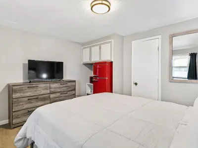 a bedroom with a white bed and a red refrigerator at Charming Retro Property #3! in Sparks