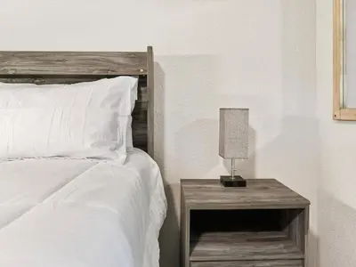 a bedroom with a bed and a nightstand with a lamp at Charming Retro Property 8 in Sparks