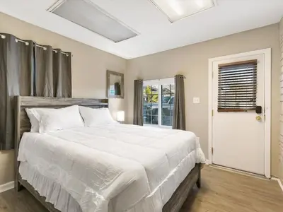 a bedroom with a large white bed and a door at Charming Retro Property 22 in Sparks