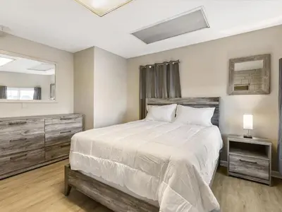 a bedroom with a large white bed and a mirror at Charming Retro Property 22 in Sparks