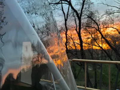 a reflection of a sunset in the windshield of a car at Enchanted Forest Dome ,10-15 minutes to Kings Canyons-New pellet stove for cozy warm nights in Dunlap