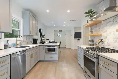 a large kitchen with white cabinets and a stove at East Sac Getaway, Walking Distance to Hospitals in Sacramento