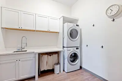 a kitchen with a sink and a washer and dryer at Meadowlark in Tahoe Donner - Modern 4BR w great views, hot tub & HOA amenities in Truckee