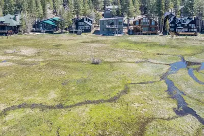 a field of grass with houses in the background at Meadowlark in Tahoe Donner - Modern 4BR w great views, hot tub & HOA amenities in Truckee