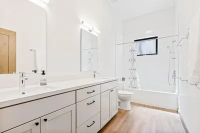a white bathroom with a sink and a tub and a toilet at Meadowlark in Tahoe Donner - Modern 4BR w great views, hot tub & HOA amenities in Truckee