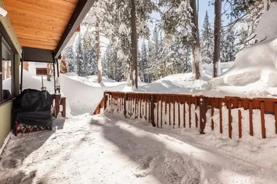 a porch covered in snow next to a house at Quaint Cabin in Serene Lakes - Close to Skiing! in Soda Springs
