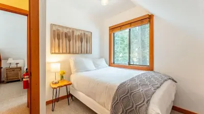 a small bedroom with a bed and a window at Minutes to Skiing Lake Hot Tub Fire Pit Deck Indigo Owl by AvantStay in Homewood