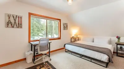 a bedroom with a bed and a desk and a window at Minutes to Skiing Lake Hot Tub Fire Pit Deck Indigo Owl by AvantStay in Homewood