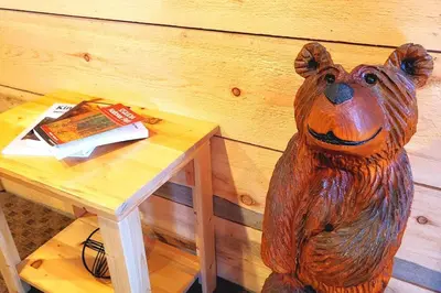 a wooden bear statue sitting next to a wooden table at Sequoia Splendor, inside Kings Canyon NP by Visitors Center in Wilsonia