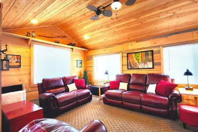 a living room with leather furniture and wooden walls at Sequoia Splendor, inside Kings Canyon NP by Visitors Center in Wilsonia