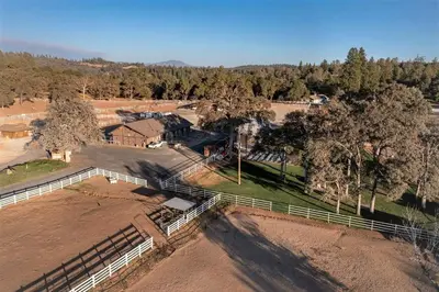an aerial view of a farm with a fence and trees at Tranquil Retreat - Home with Spacious Deck & Grill home in Groveland