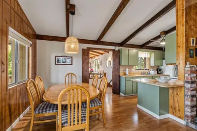 a kitchen and dining room with a wooden table and chairs at Tranquil Retreat - Home with Spacious Deck & Grill home in Groveland