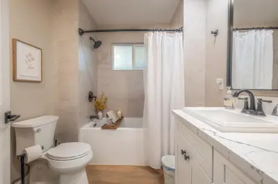 a white bathroom with a toilet and a sink at Folsom Old Town Escape in Folsom