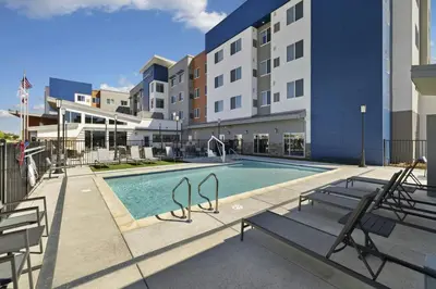 a swimming pool at a hotel with benches and buildings at Residence Inn by Marriott Lodi Stockton in Lodi