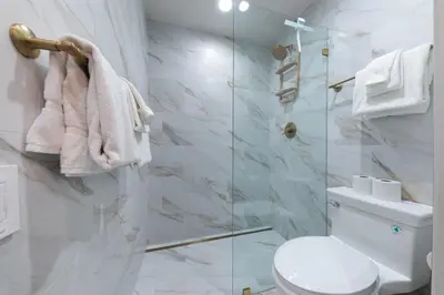 a bathroom with a toilet and a glass shower at Stylish 2BD Condo - Walk to Palisades! in Olympic Valley