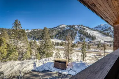 a view of a snow covered mountain with a tv at Stylish 2BD Condo - Walk to Palisades! in Olympic Valley