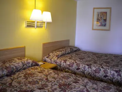 a hotel room with two beds and a lamp at Wasco Inn in Wasco