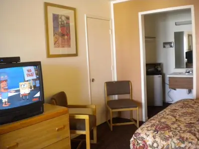 a hotel room with a television on a dresser with a bed at Wasco Inn in Wasco