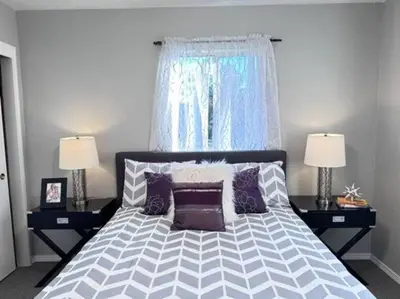 a bedroom with a bed with purple pillows and a window at Ripon Orchard Retreat in Ripon
