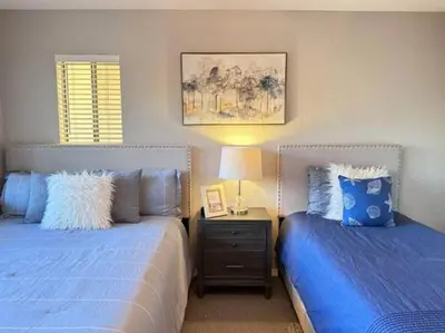 a bedroom with two beds and a table with a lamp at Ripon Orchard Retreat in Ripon
