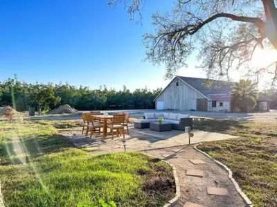 a patio with a table and chairs and a barn at Ripon Orchard Retreat in Ripon