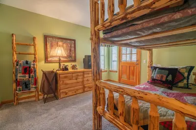 a bedroom with a wooden bunk bed and a ladder at Hideaway Down Canyon #101 in June Lake