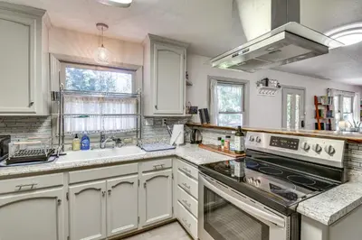 a kitchen with white cabinets and a stove top oven at Lake Access and Hot Tub Pet-Friendly Arnold Home in Arnold