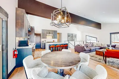 a kitchen and living room with a table and chairs at Mountain Majesty in Truckee