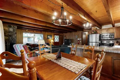 a kitchen and living room with a wooden table and chairs at Cardinal's Nest in Groveland