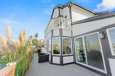 a house with glass doors and a balcony at * Large Updated Waterfront Delta Manor Boat Dock * in Discovery Bay