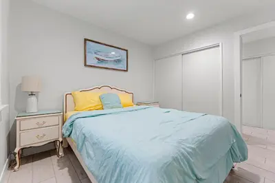 a white bedroom with a bed and a nightstand with a bed sidx sidx sidx at * Large Updated Waterfront Delta Manor Boat Dock * in Discovery Bay