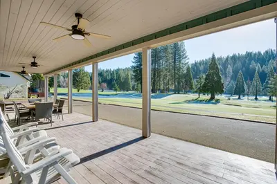 a screened porch with chairs and a ceiling fan at Game Room and Pool Access Spacious Cabin in Arnold in Arnold