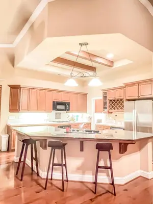 a kitchen with a large island with two bar stools at Pickleball Retreat near Bass Lake & S. Yosemite in Ahwahnee