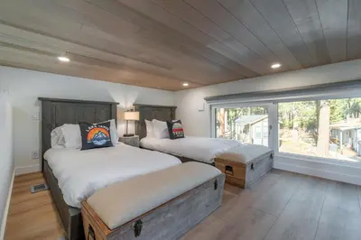 a bedroom with two beds and a large window at Village Camp Truckee in Truckee