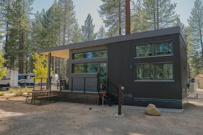 a black tiny house in the woods at Village Camp Truckee in Truckee